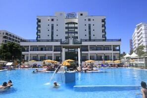 Una piscina al aire libre, sombrillas, sillones reclinables de piscina