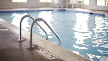 Una piscina techada, sillones reclinables de piscina