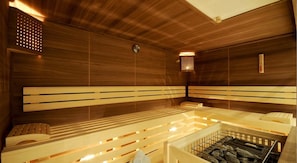A sauna with wooden benches and a stone floor.