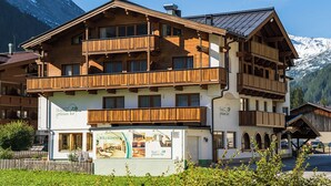 Un hotel de varios pisos con balcones de madera y un cartel que anuncia 'Hotel gruenen tor'.