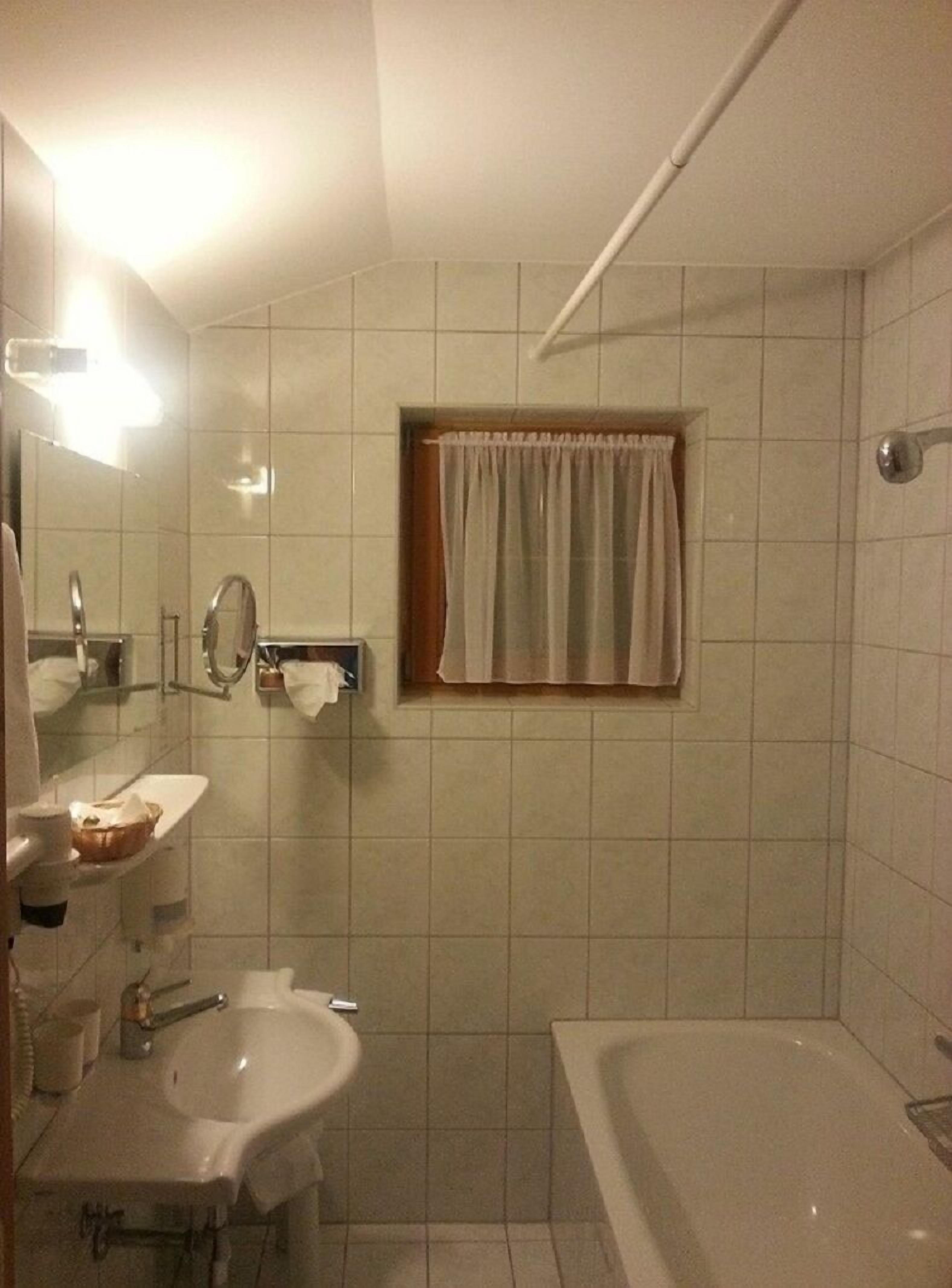 Un baño con lavabo, espejo y bañera.