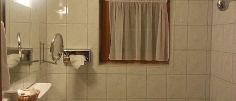 Un baño con lavabo, espejo y bañera.