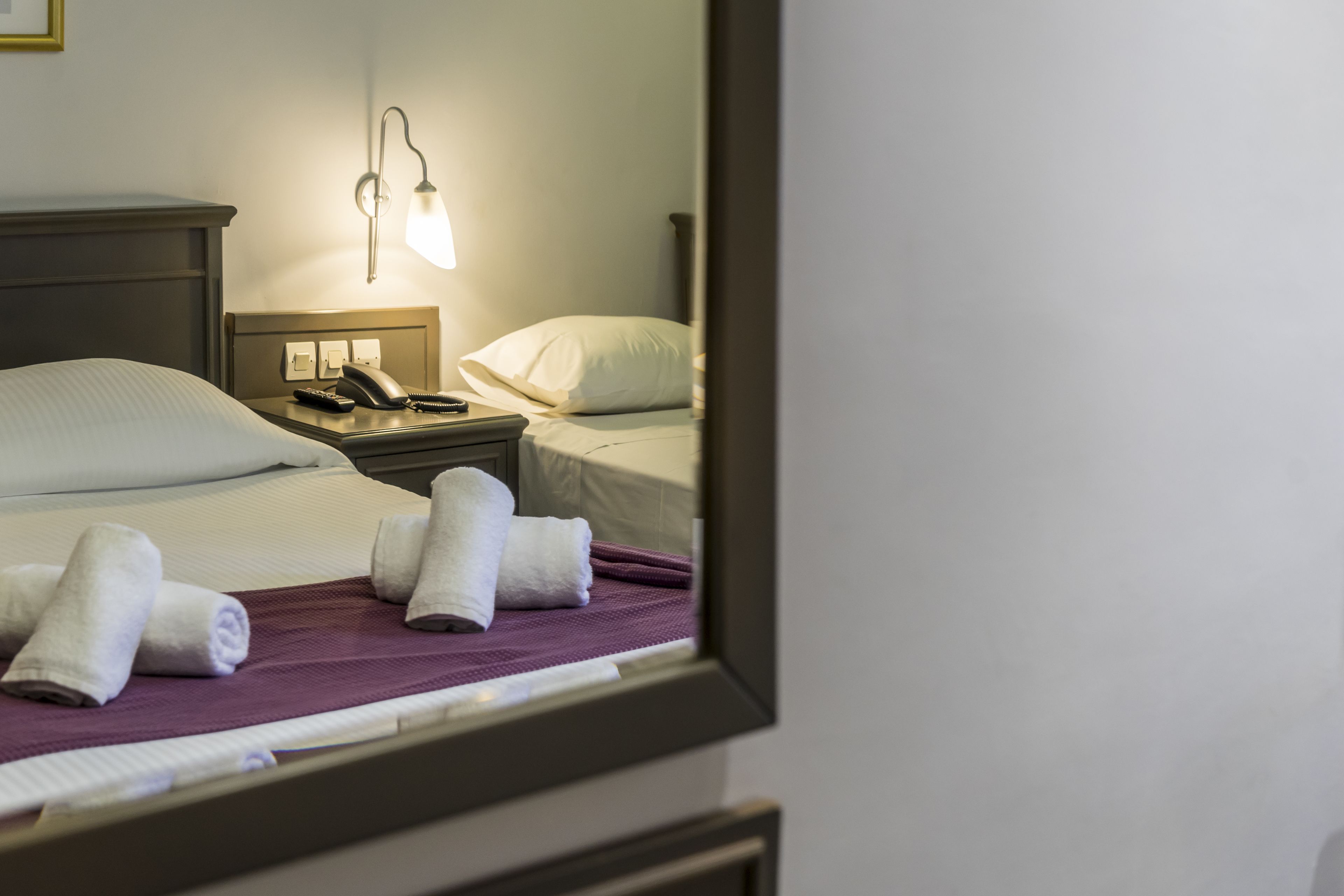 Une chambre d’hôtel avec un lit, une table de chevet avec une lampe et un téléphone.