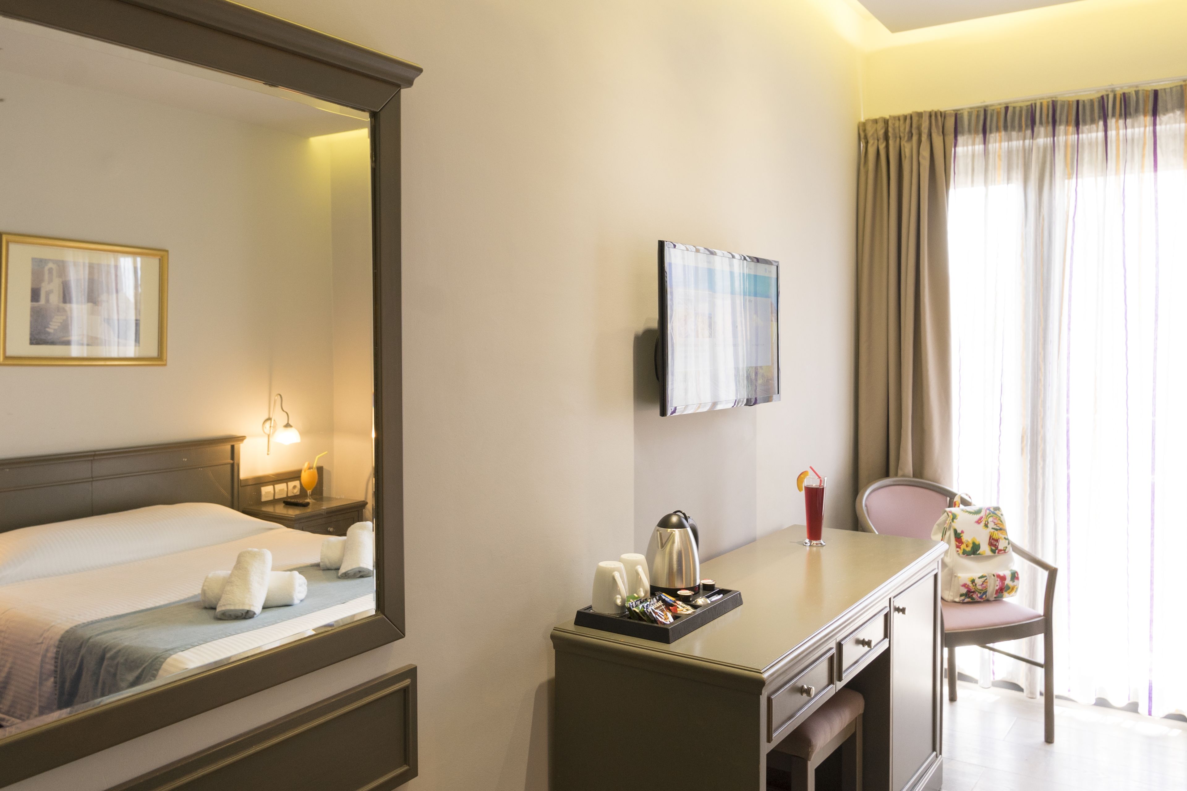 A hotel room with a bed, bedside table, lamp, and a chair.