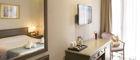 A hotel room with a bed, bedside table, lamp, and a chair.