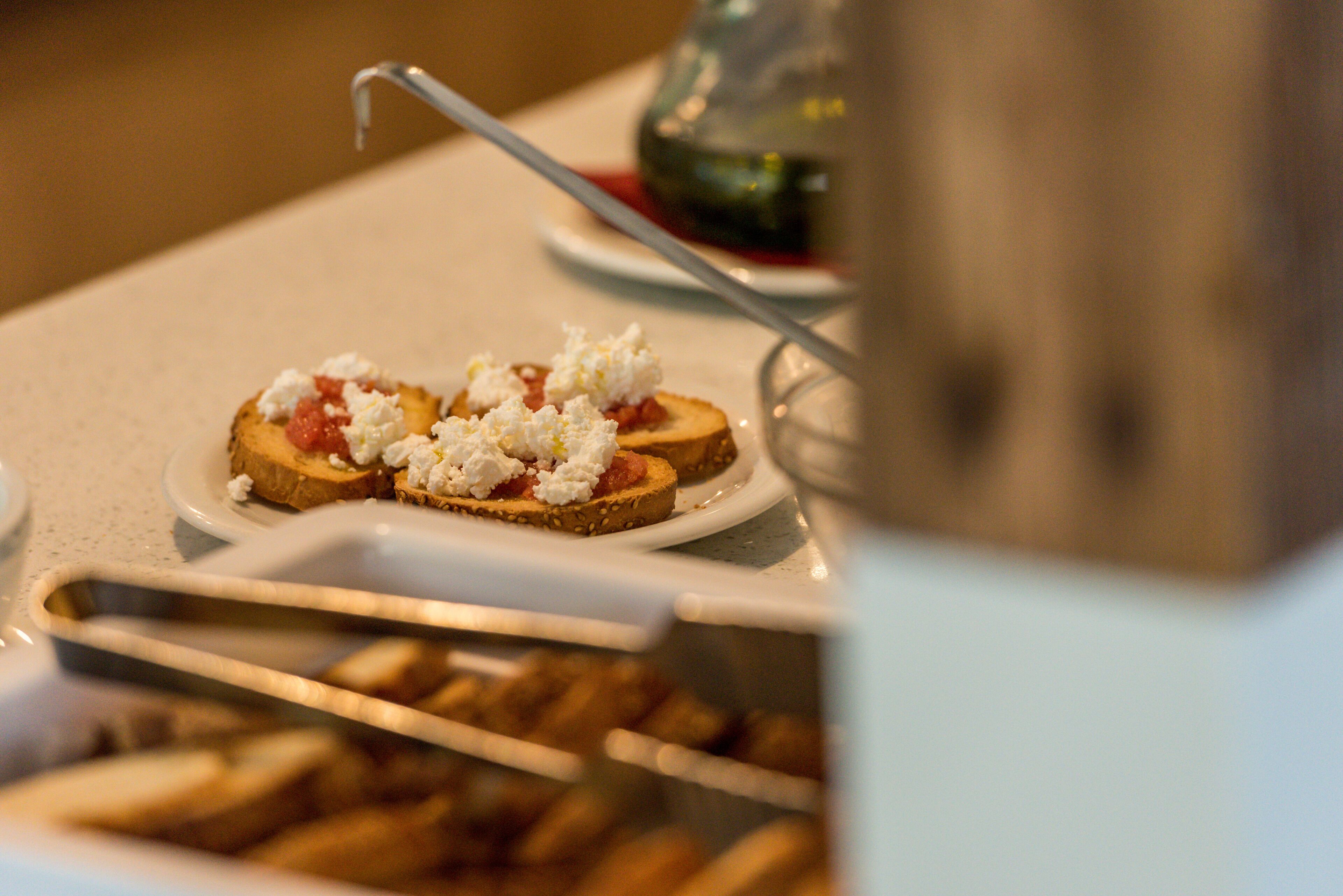 Un bufé de desayuno con tostadas cubiertas de tomate y queso.