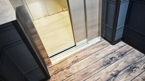 A wooden floor with a door leading to a room with a light-colored wall and a dark-colored cabinet. - Das Landhotel Am Trätzhof (Fulda)