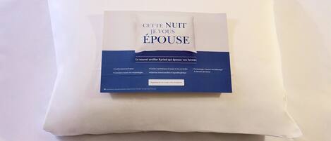 A pillow with a tag that reads "CETTE NOUITE JE VOUS ÉPOUSE" and mentions a new pillow called Kriad.