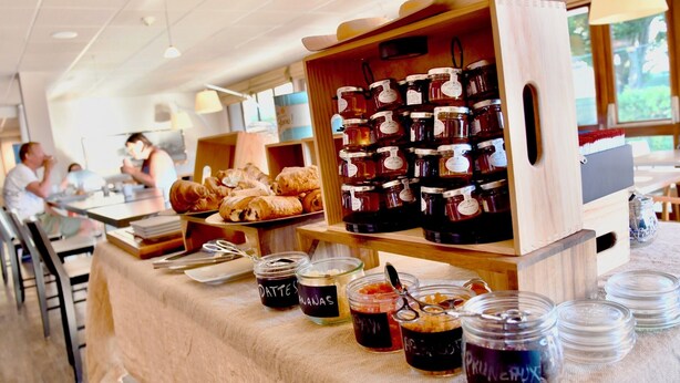 A buffet area with various food items and jars of preserves.