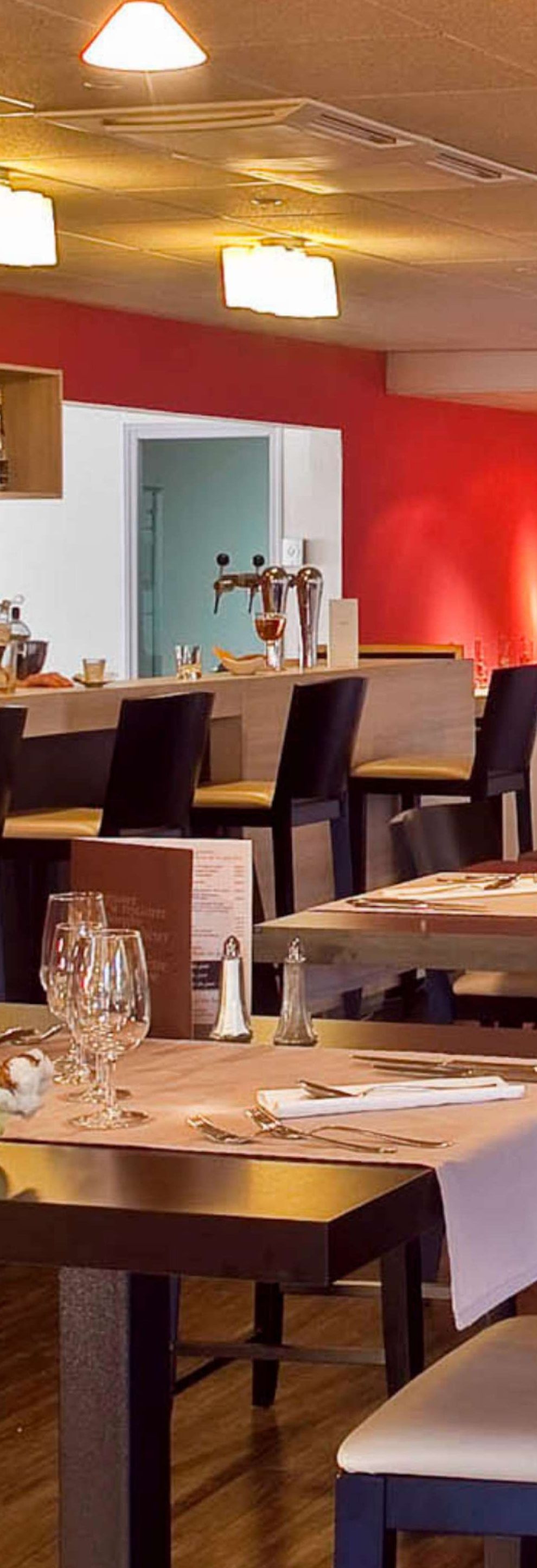 Un interior de restaurante con mesas, sillas y un atril para el menú.