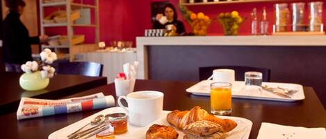 A breakfast setup with croissants, coffee, and orange juice on a tray.
