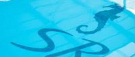 Piscina com superfície de água azul cristalina e um logotipo no chão.