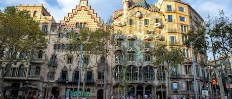 Un bâtiment historique aux façades richement décorées, doté de grandes fenêtres et d’une tour imposante.