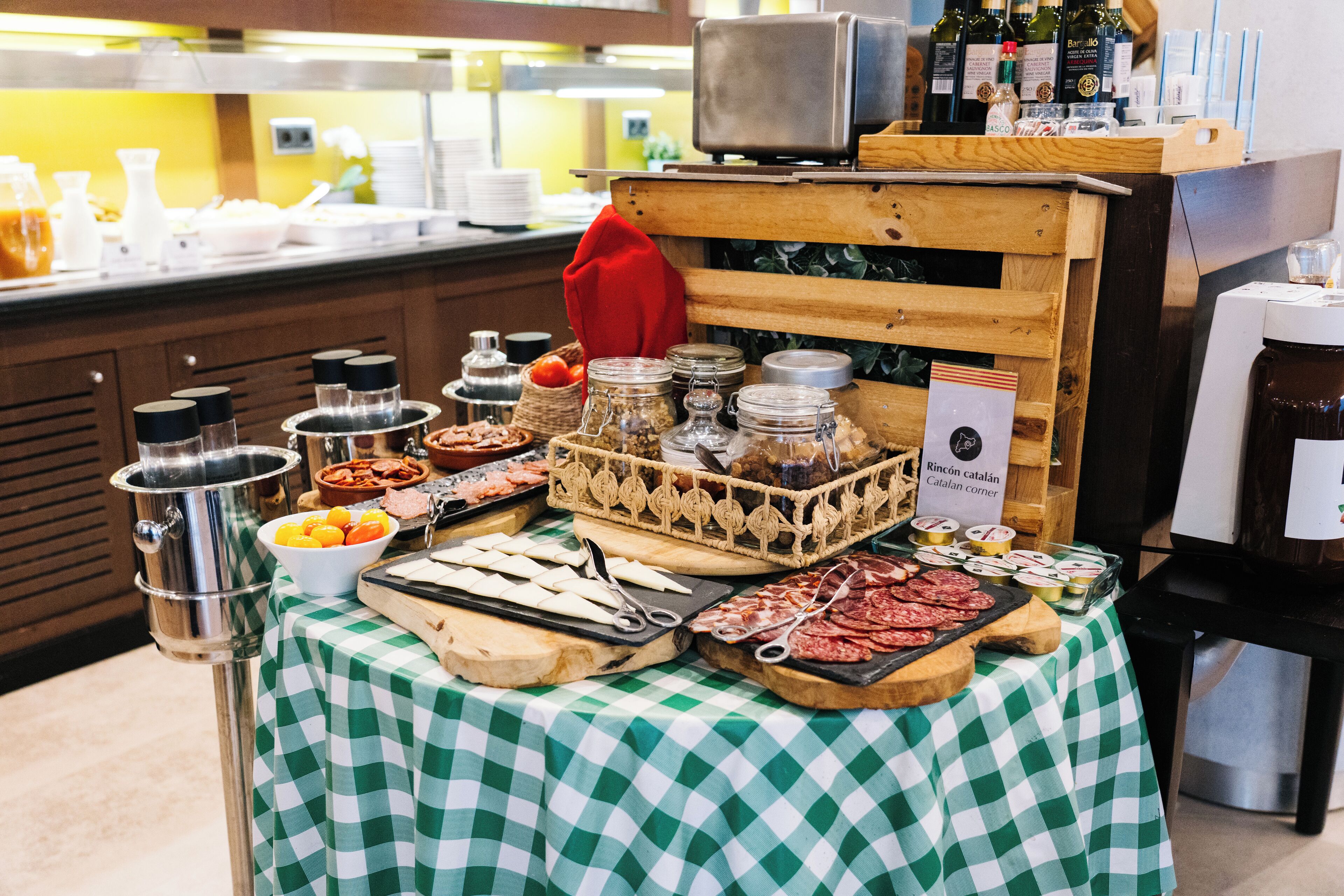 A buffet table with various food items and condiments, a coffee machine, and a wine cooler.