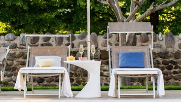 Utomhuspool, parasoller och solstolar