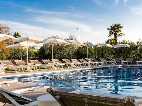 Outdoor pool, pool umbrellas, sun loungers. Hotel Ca' Mura