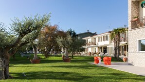 A well-maintained outdoor area with a lawn, potted plants, and outdoor seating.