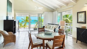 A spacious living area with a balcony overlooking a tropical beach. - Ocean Club West, Grace Bay Beach (Providenciales)