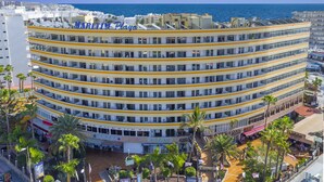A multi-story hotel with a curved facade, located near a beach. - Apartments Maritim Playa - Adults Only (San Bartolomé de Tirajana)