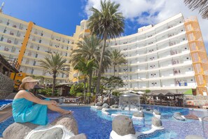 A hotel pool area with a large pool, palm trees, and a multi-story building in the background. - Apartments Maritim Playa - Adults Only (San Bartolomé de Tirajana)