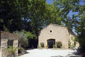 Traditional stone building with an arched entrance and lush surroundings.