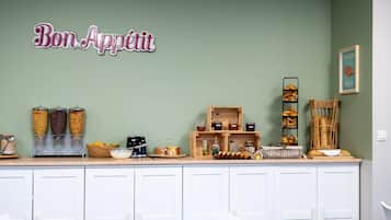 Un comptoir de cuisine avec des pots d’assaisonnements, une machine à café et une pancarte sur laquelle on peut lire « Bon appétit ».
