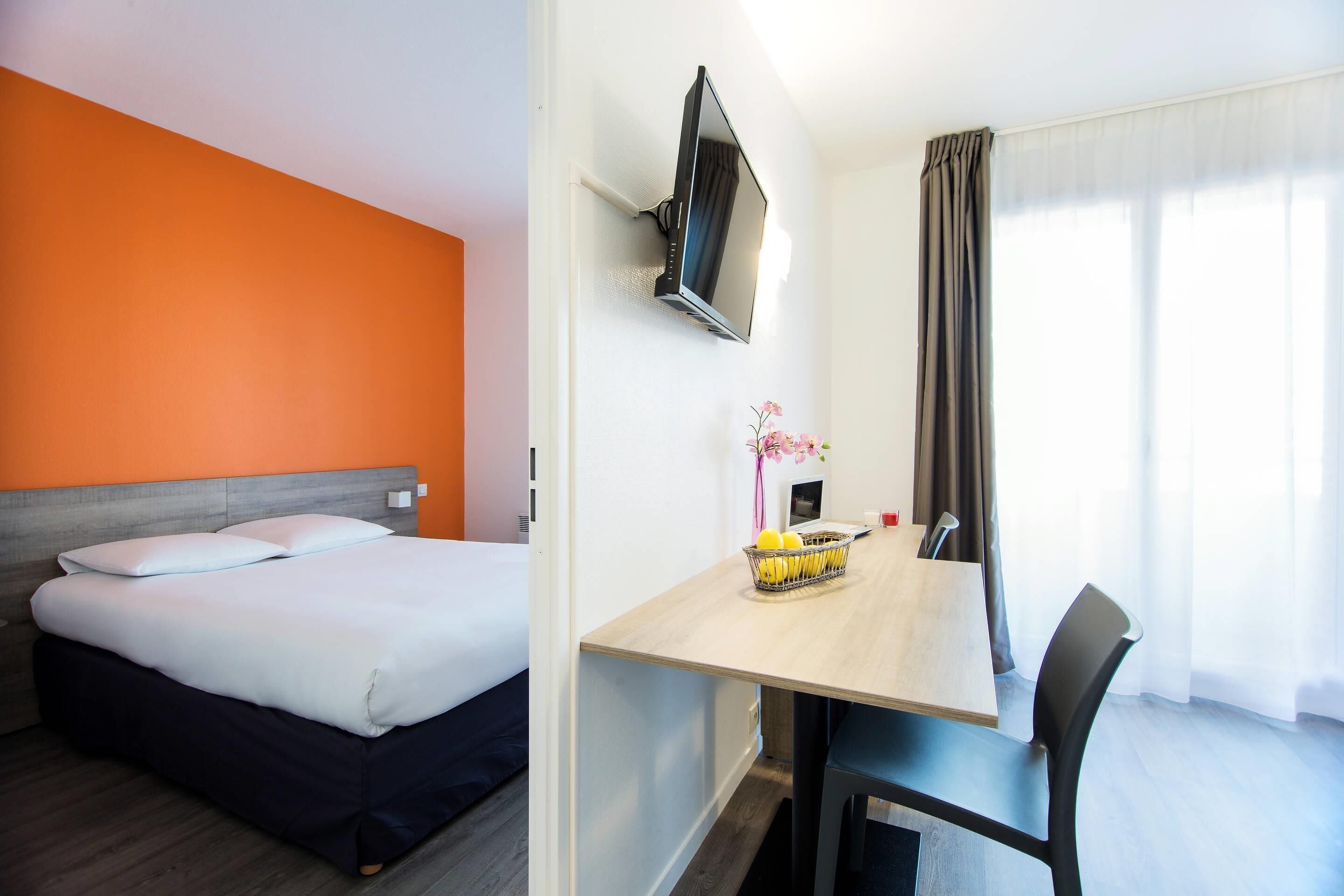 Een hotelkamer met een bed, een bureau en een stoel.