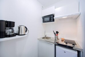 A compact kitchenette with a microwave, coffee maker, sink, and a small refrigerator. - Comfort Aparthotel Toulouse Metropole (Toulouse)