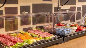 Un buffet con diverse carni, insalate e salse.