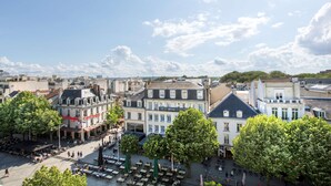 En historisk bygning med caféterrasse og udendørs siddepladser.