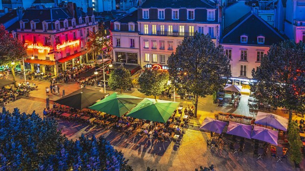 A hotel with outdoor seating and a red neon sign. - Best Western Hôtel Centre Reims (Reims)