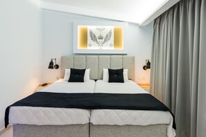 A modern hotel room with a large bed, grey headboard, and a wall-mounted artwork. - Ionis Art Hotel (Zakynthos)