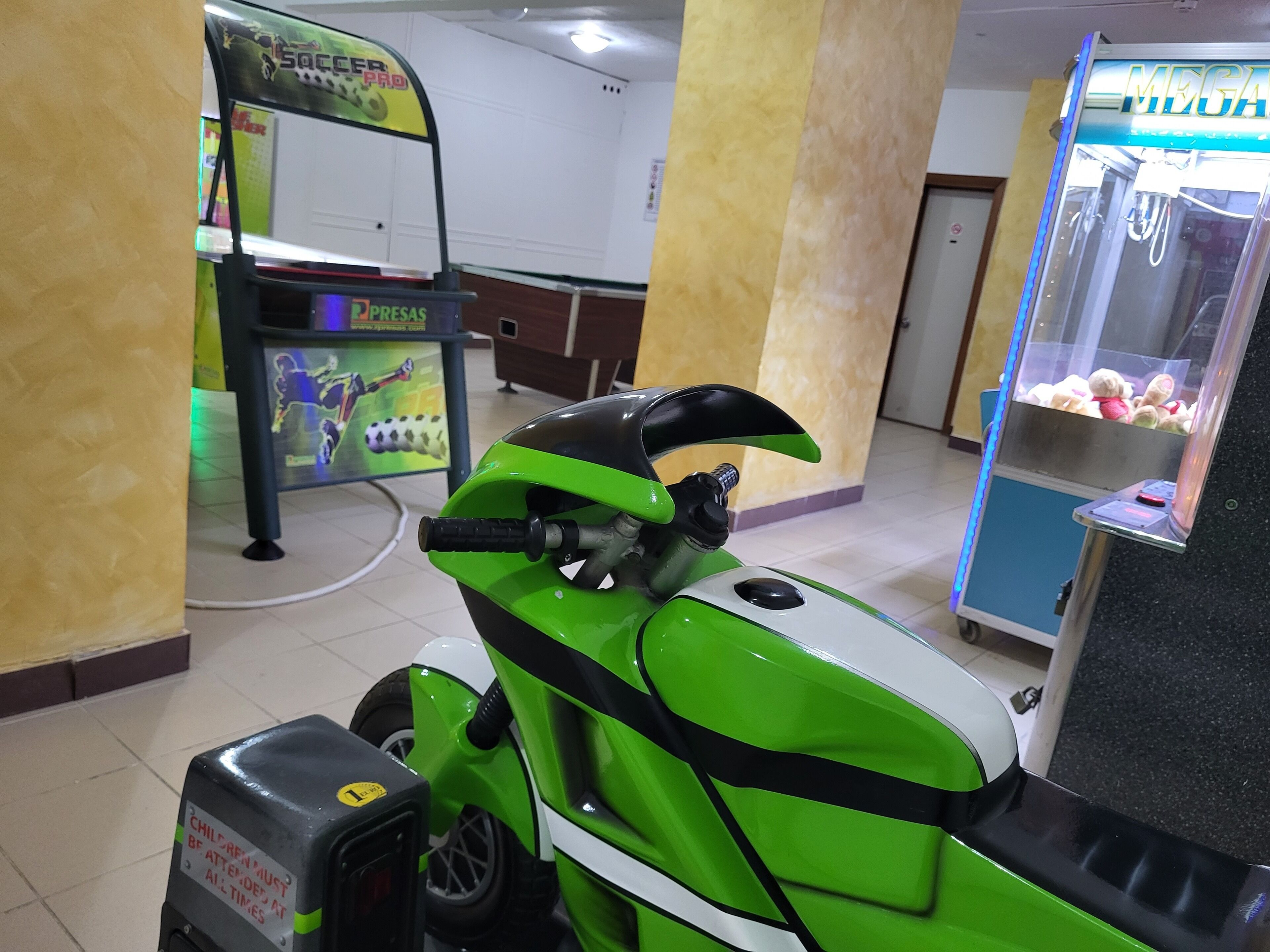 A green scooter with a black handlebar and a rear storage compartment.