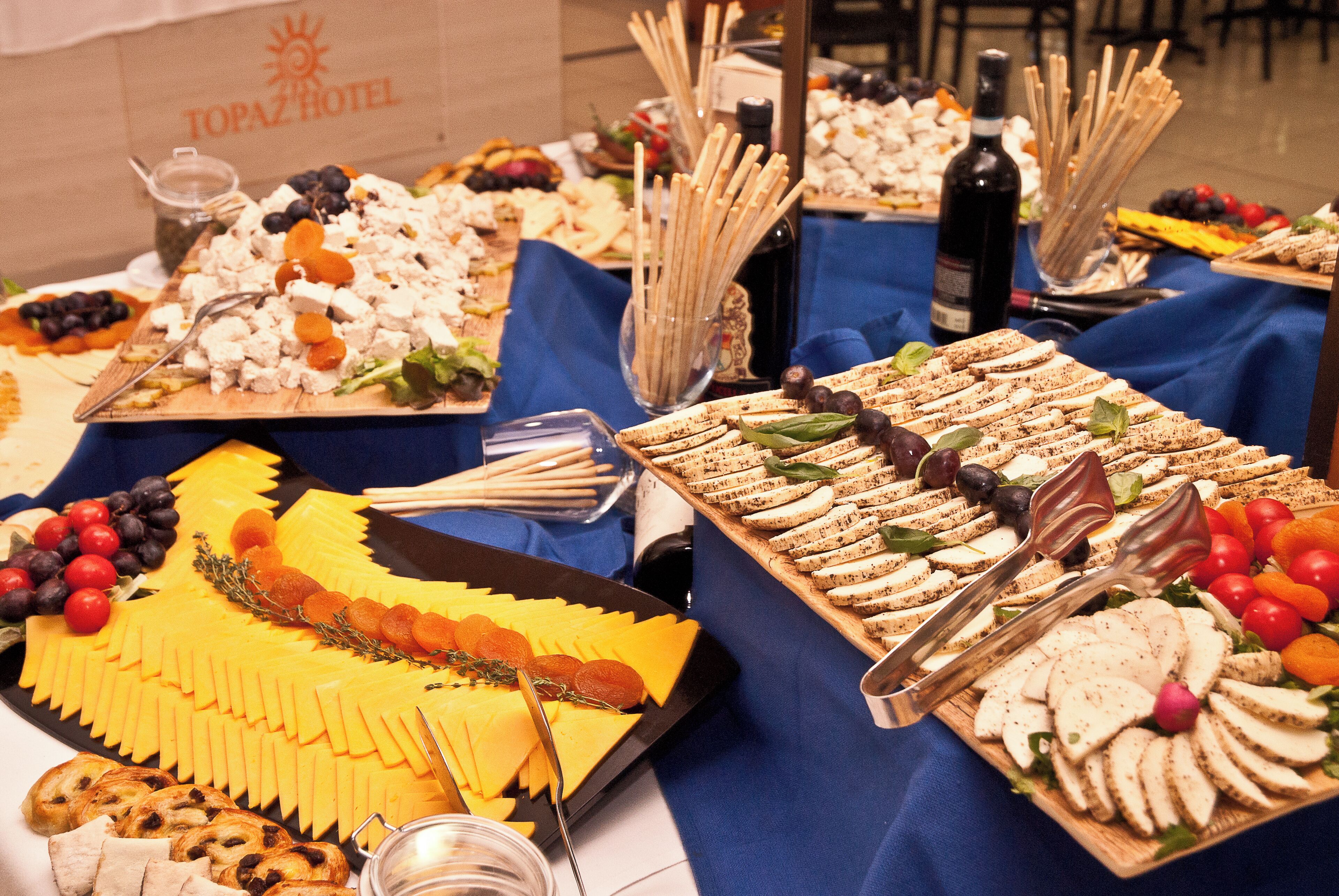 Una mesa de buffet con diversos quesos, frutas y pan.