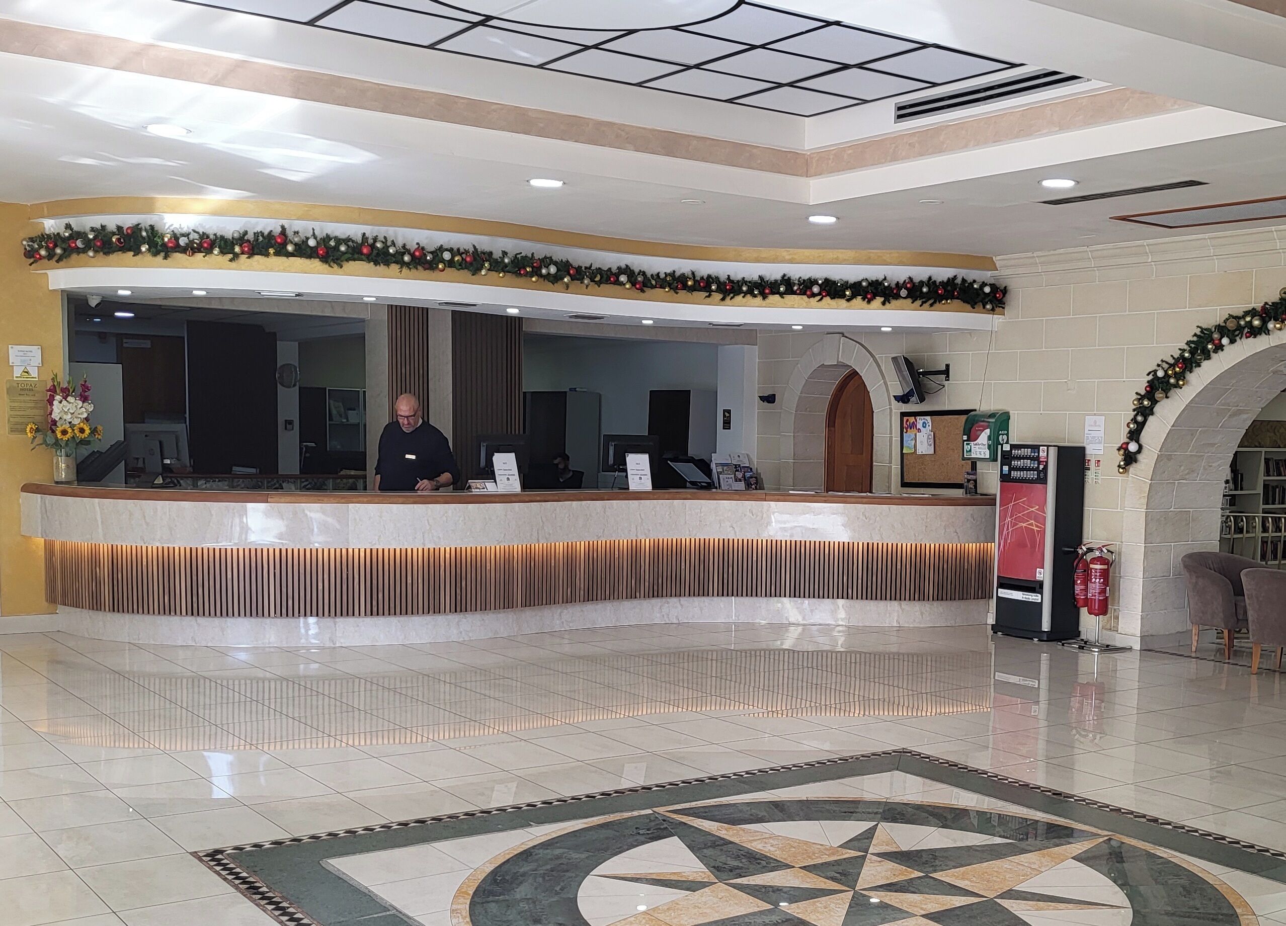 A reception area with a marble counter, a fire extinguisher, and a vending machine.