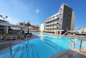 Piscine couverte, piscine extérieure, parasols de plage, chaises longues