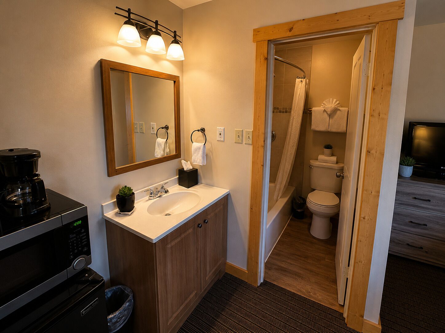 A modern bathroom with a wooden vanity, a sink, a mirror, and a shower area.