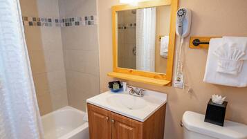 Une salle de bain équipée d’une baignoire, d’un lavabo, de toilettes et d’un rideau de douche.