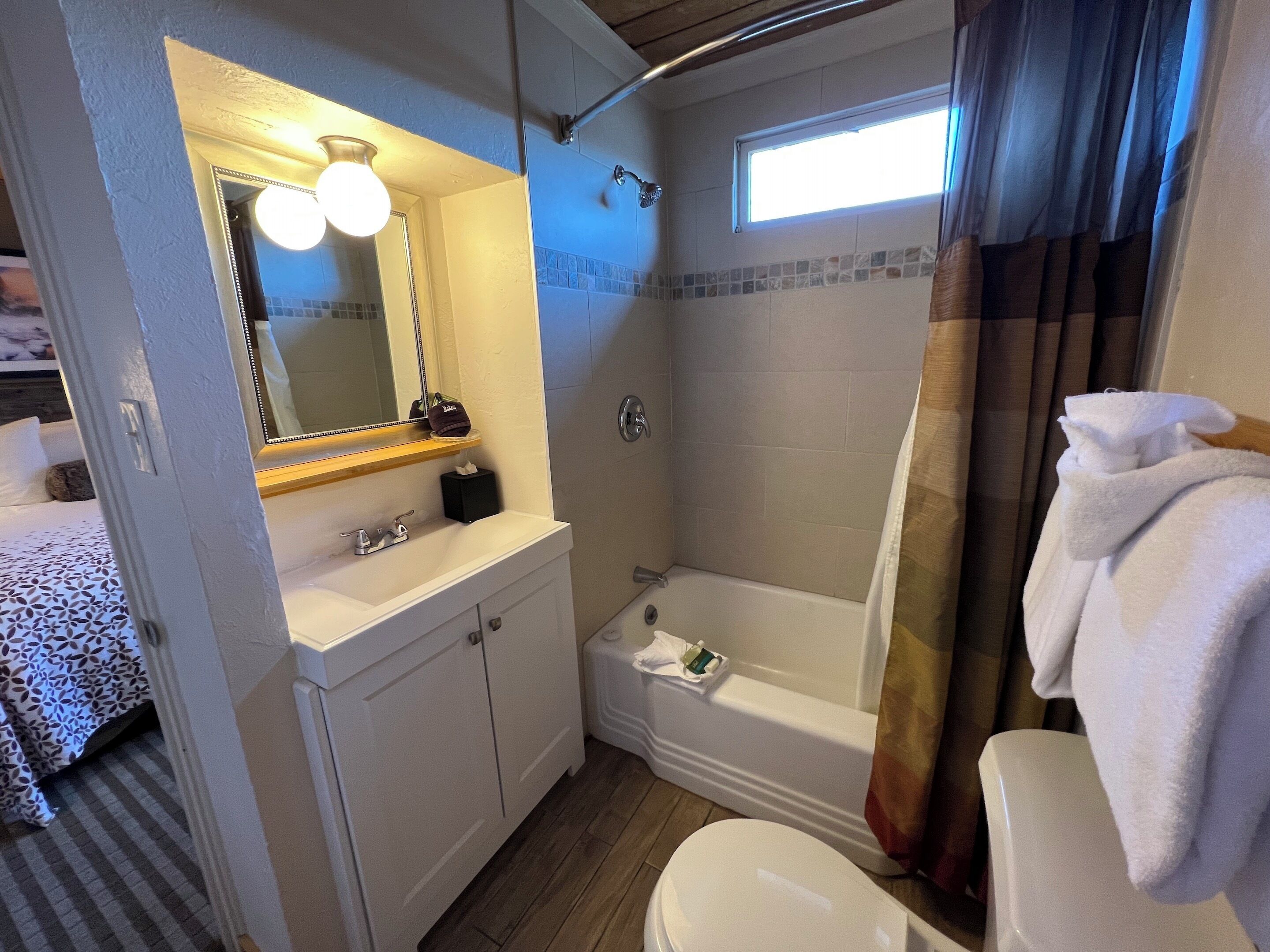 A compact bathroom with a shower, toilet, and sink.