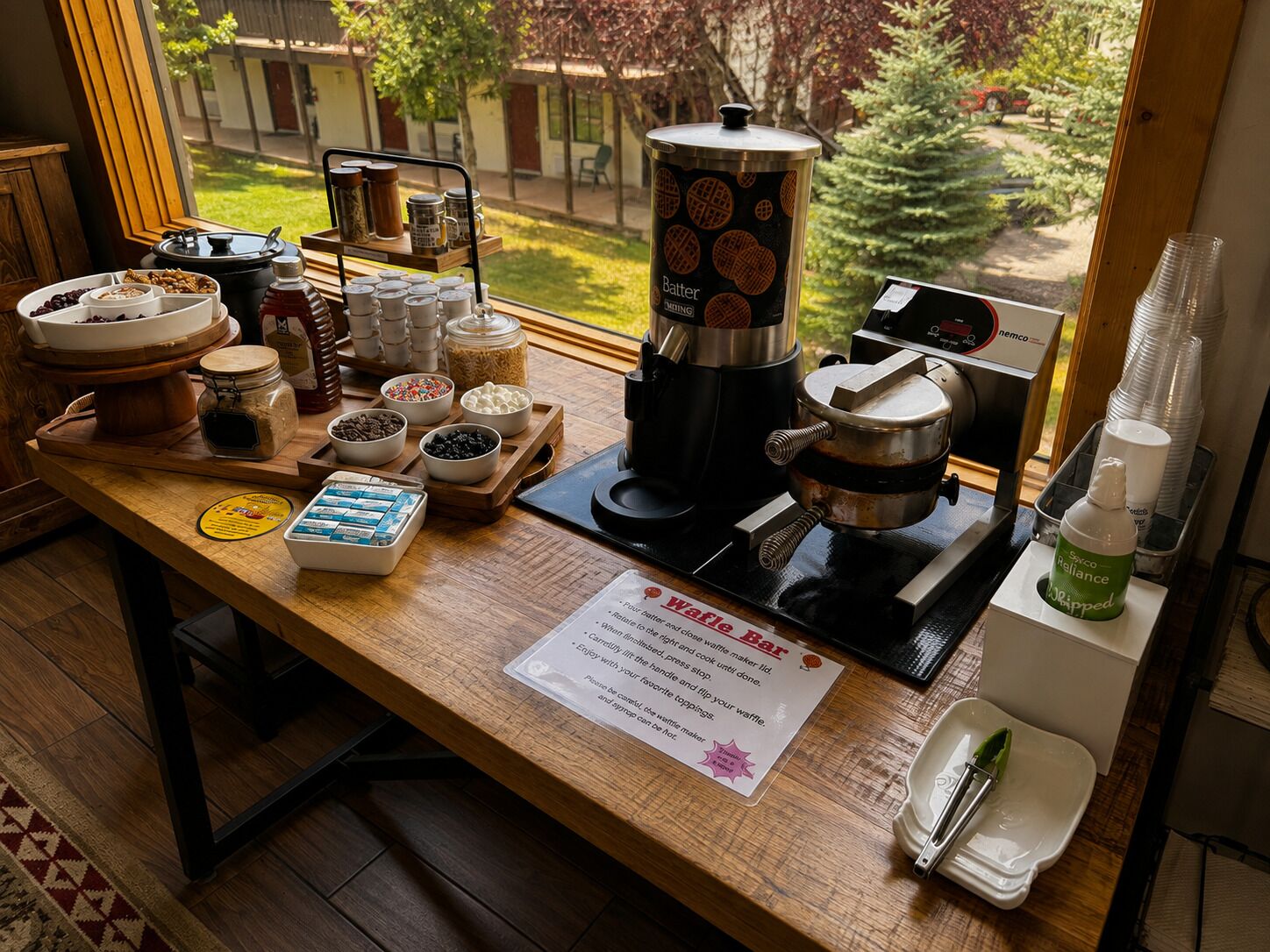 En köksbänk med en våffeljärn, en kaffebryggare och diverse livsmedel.