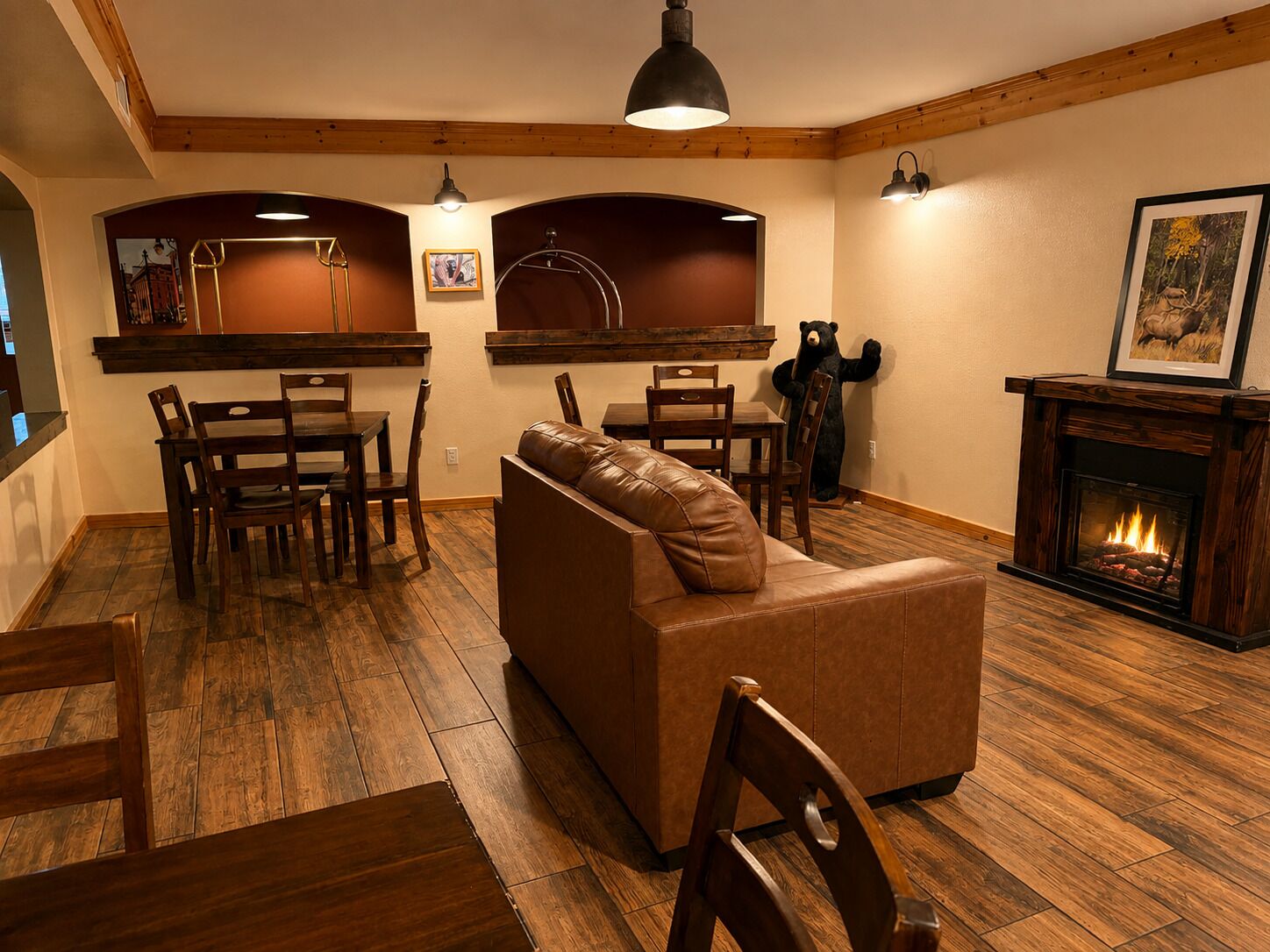 Una sala de estar acogedora con chimenea, suelo de madera y un sofá de cuero.
