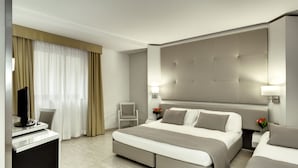 Una habitación de hotel moderna con una cama grande, un escritorio y un televisor.