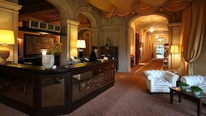 A lobby with a reception desk, seating area, and a hallway leading to other rooms.