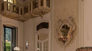A grand room with ornate ceiling decorations, a large mirror, and a buffet table with various food items.