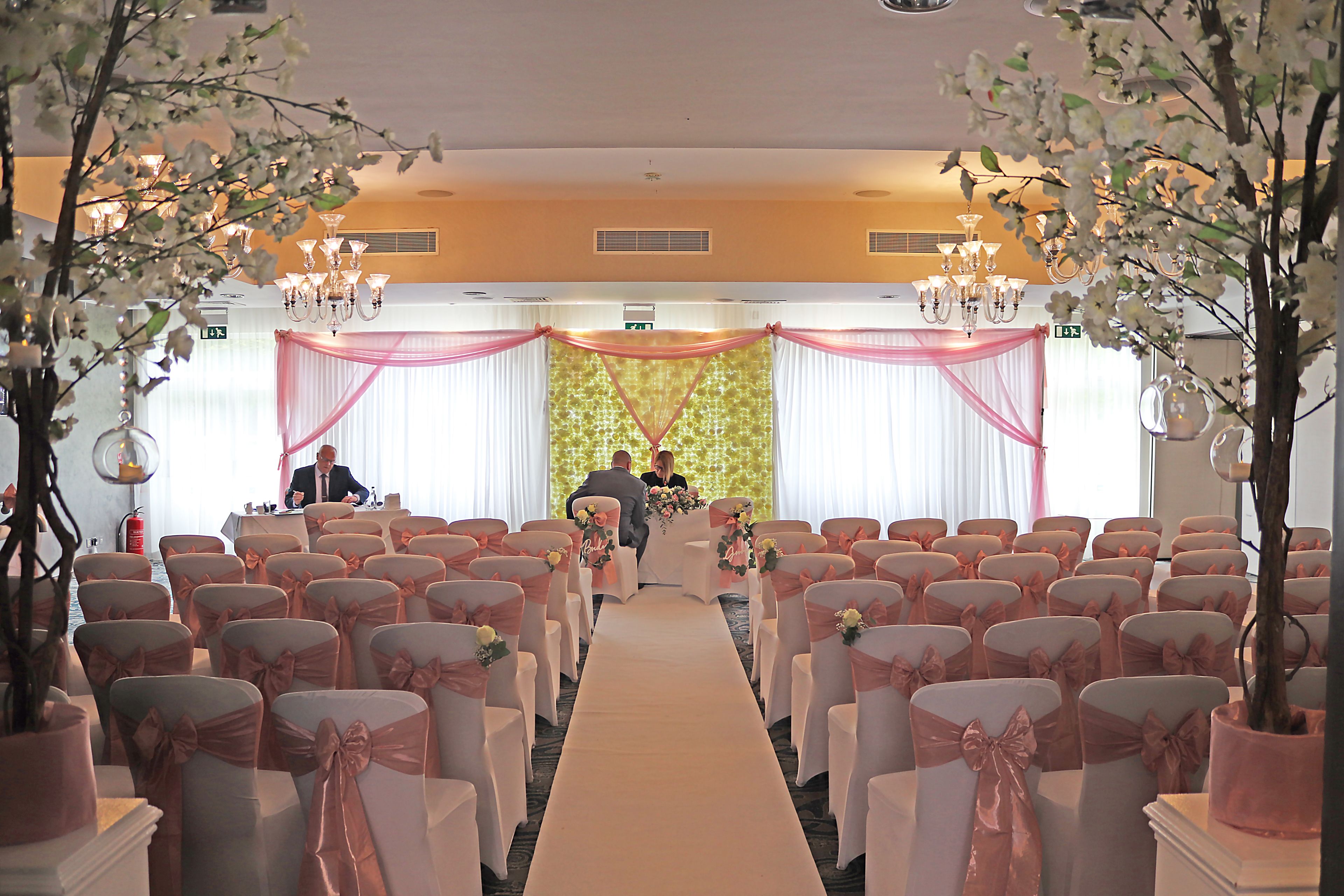 Une allée où se déroule la cérémonie de mariage, avec des chaises et un pupitre.