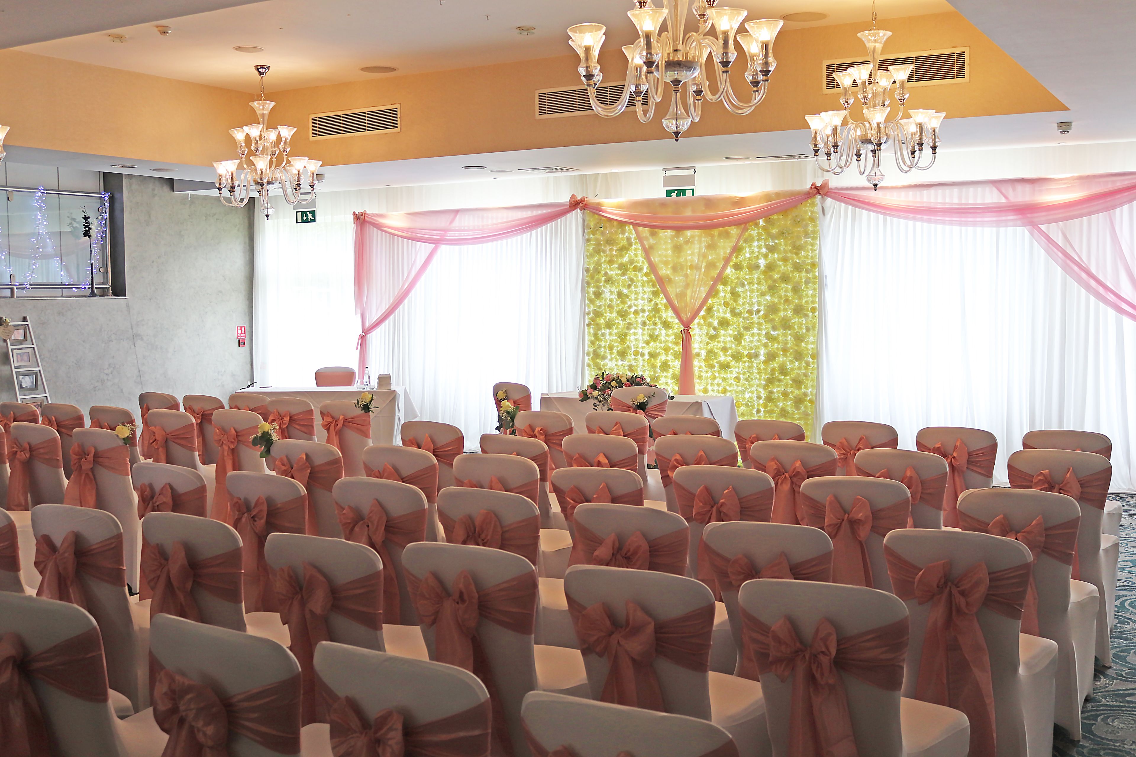 Un salón de conferencias con filas de sillas, un escenario y candelabros.
