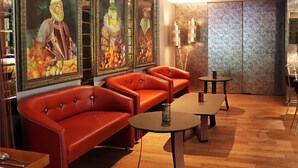 Ein Zimmer mit roten Ledersofas, einem kleinen Tisch und Wandbildern.