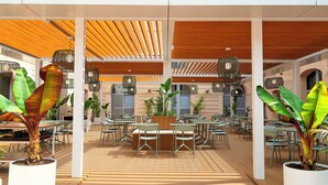 Un patio al aire libre con mesas, sillas, plantas en macetas y lámparas de mimbre colgantes.
