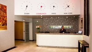A reception desk with clocks indicating Dubai, Casablanca, Paris, and New York. - Hôtel Les Saisons (Casablanca)