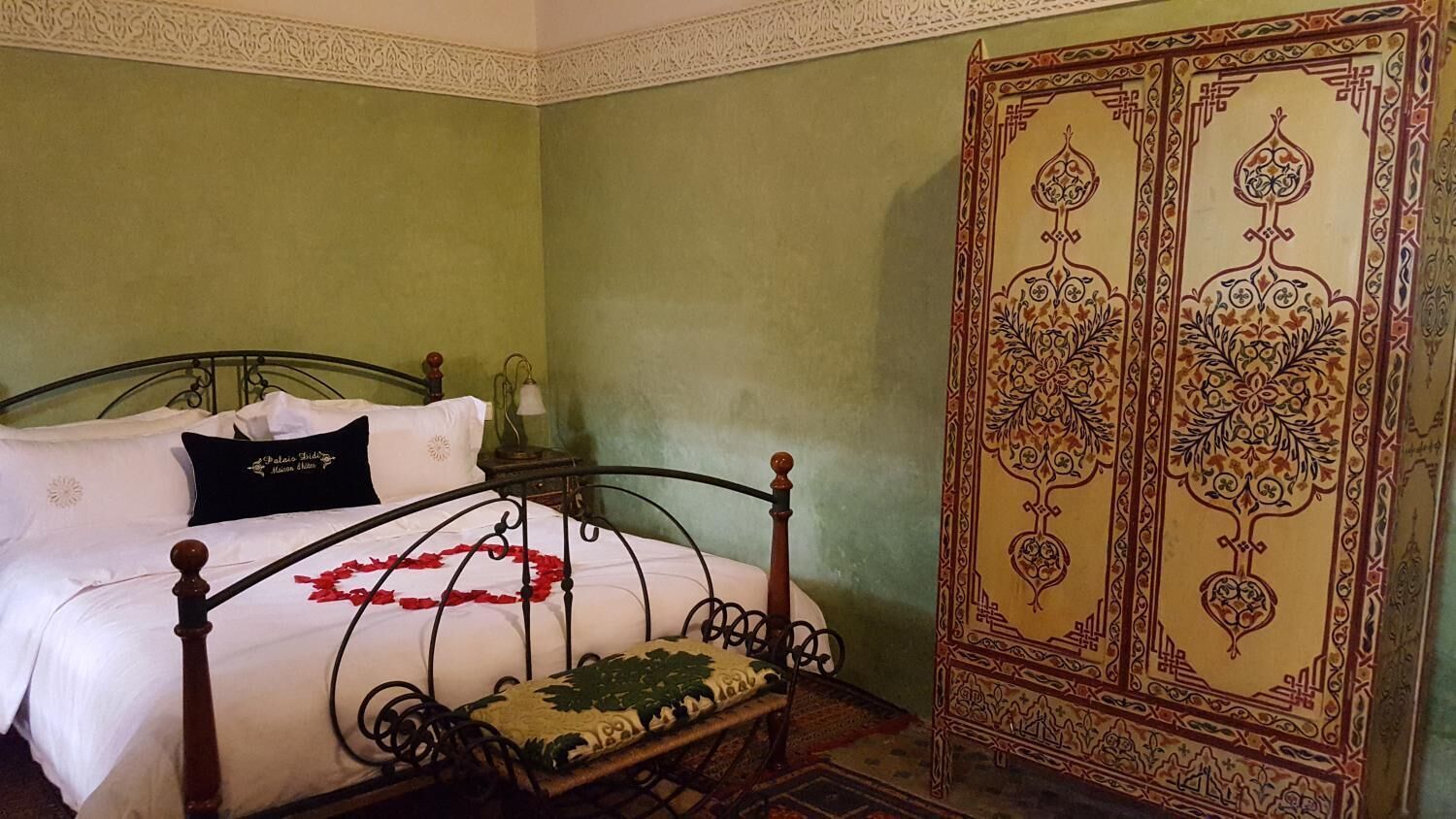 Une chambre à coucher avec un lit, une table de chevet et une armoire.
